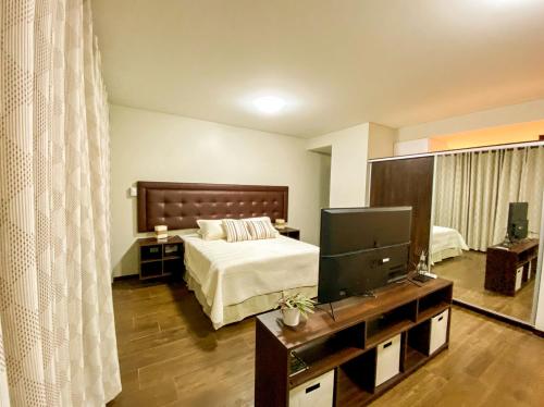 圣克鲁斯Departamento Elegante y Relax by Torre Vento的一间卧室配有一张床和一台平面电视