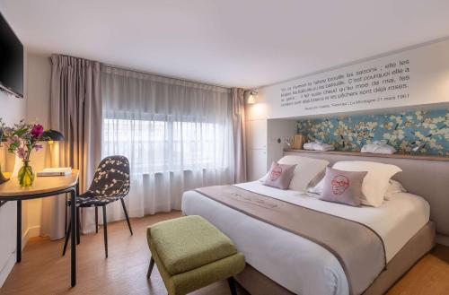 克莱蒙费朗Hotel Litteraire Alexandre Vialatte, BW Signature Collection的酒店客房设有一张大床和一张书桌。