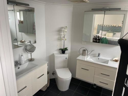 悉尼Shared Beachfront Living的浴室设有卫生间、2个盥洗盆和镜子