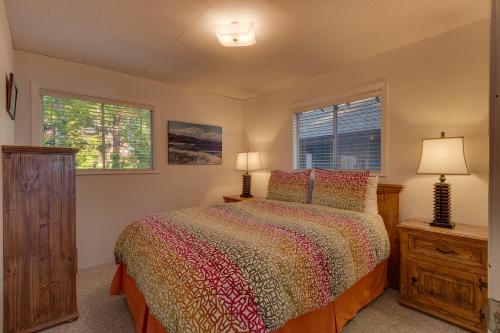 霍姆伍德Evans Lakeview- Hot Tub- Fireplace- Walk To Lake- Minutes to Homewood Resort的一间卧室设有一张床和两个窗户。