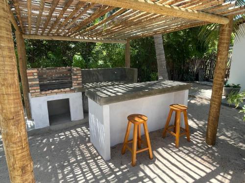 伊卡普伊Casa Mandakarú的户外酒吧,在木凉棚下设有2把凳子