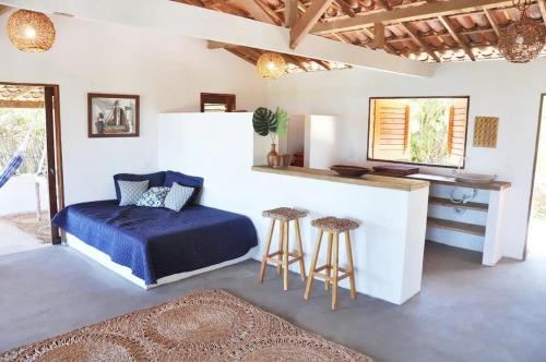 伊卡普伊Casa Mandakarú的一间卧室配有一张床、一个柜台和凳子