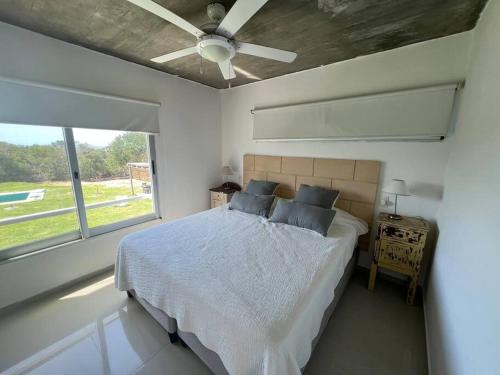 何塞伊格纳西奥Tranquilidad, playa y naturaleza的一间卧室配有一张床和吊扇