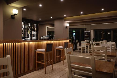 戈里察Hotel Romeo的一间带桌椅的餐厅和一间酒吧
