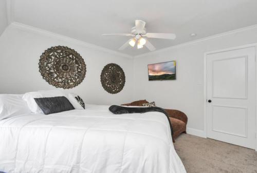 休斯顿Peaceful Queen Master Suite的卧室配有白色的床和吊扇