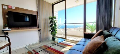 安托法加斯塔MC Suite Norte - Vista al mar的客厅设有蓝色的沙发和大窗户