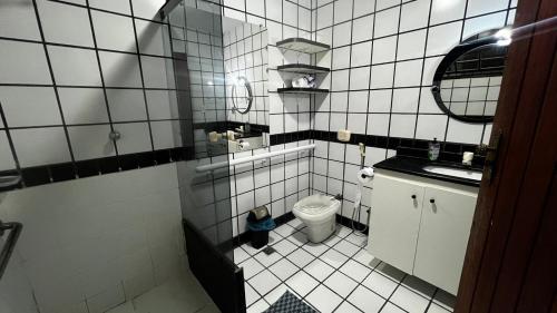维多利亚Sossai Hostel的白色瓷砖小浴室设有卫生间和水槽