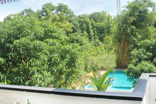 锡吉里亚锡吉里亚阳光别墅的阳台享有游泳池和树木的景致。