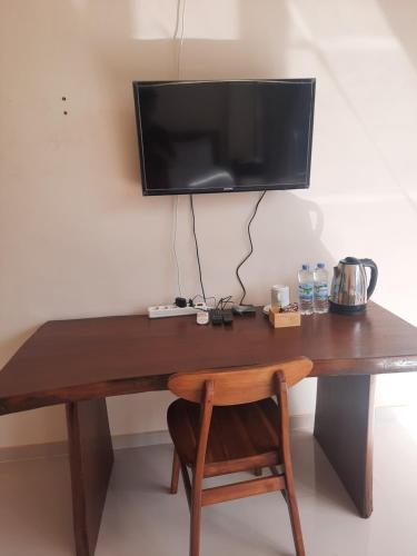 KalibendoL'JAVAS VILLAS的一张木桌,墙上有电视