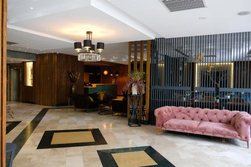 ÇekirgeTurk Inn Ferro Hotel的大堂在房间内配有粉红色的沙发