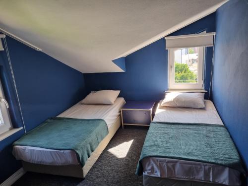 凯麦尔Villa Xenia的蓝色客房的两张床,设有窗户