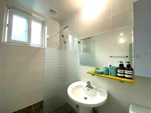束草市Smile Resort的白色的浴室设有水槽和淋浴。