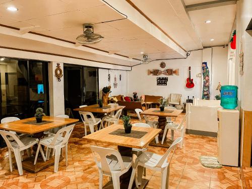 科隆Mario's Travellers Inn的配有木桌和白色椅子的餐厅