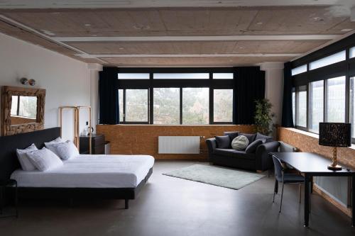 赖斯韦克Urban Hotel The Golden Stork的一间卧室配有一张床、一张沙发和窗户。