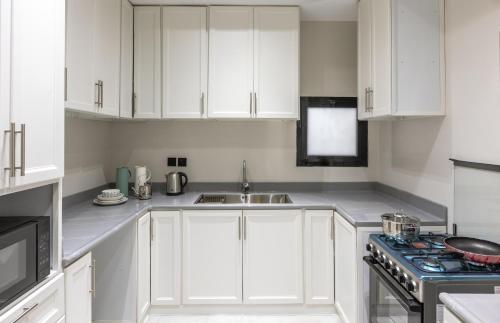 麦地那شقة غرفتين وصالة ومطبخ的白色的厨房配有白色橱柜和水槽