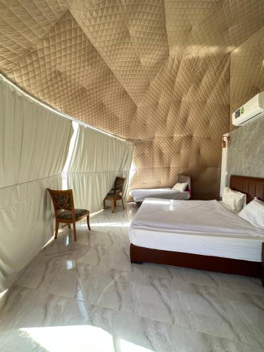 瓦迪拉姆Wadi rum camp的一间卧室配有一张床,帐篷内配有两把椅子
