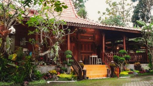 斯勒曼Cokro Hinggil - Traditional View的花园中种有树木和植物的房子
