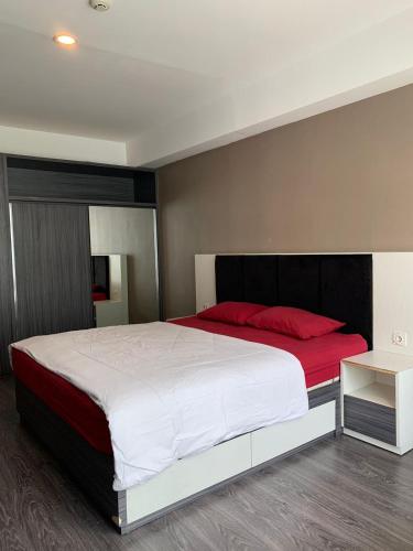 科贾扬Vins Room at Mataram City Tower Sadewa的卧室配有带红色枕头的大型白色床