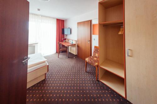Neusorg桑恩塔尔酒店的配有一张床和一张书桌的酒店客房