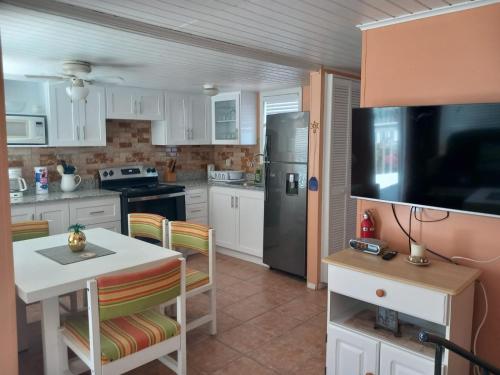 弗利盖特湾希罗夫茨海滩上酒店的厨房配有白色橱柜和黑色冰箱。