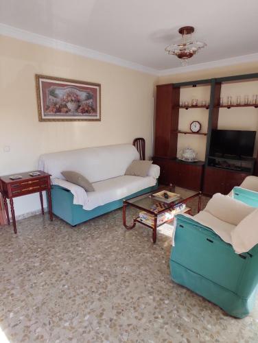 贝莱斯Piso Vélez Málaga的客厅配有两把椅子和一张沙发