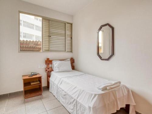 戈亚尼亚Itajubá Classic Hotel Goiânia的一间小卧室,配有一张床和镜子
