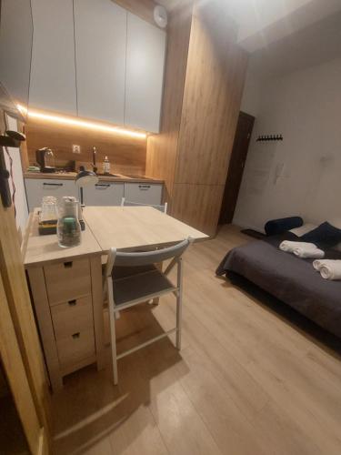 比得哥什Apartamenty Jaskółcza的一个带书桌的厨房和一张位于客房内的床