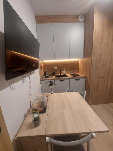 比得哥什Apartamenty Jaskółcza的厨房配有木桌和水槽。