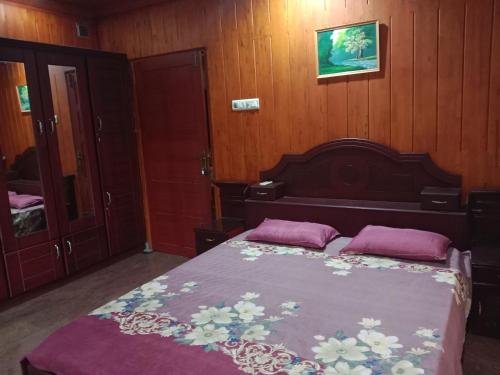 德里久尔Pournami Home Stay的一间卧室配有一张带两个枕头的床
