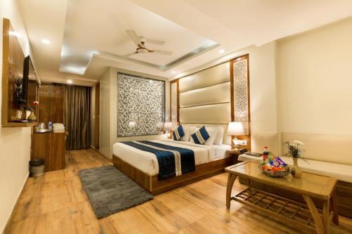 新德里OPO Hotel Viva Palace的酒店客房配有一张床铺和一张桌子。