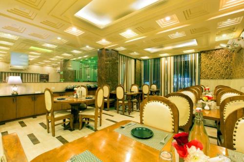 新德里OPO Hotel Viva Palace的一间带桌椅的用餐室和一间厨房