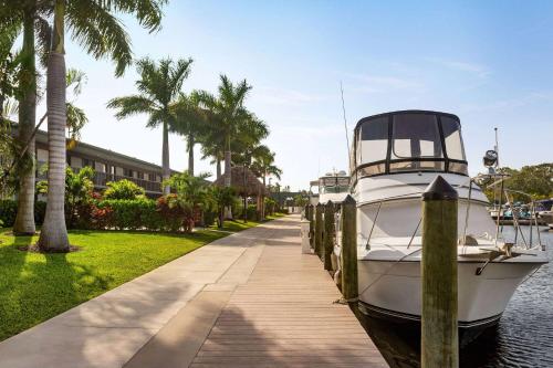 萨拉索塔Ramada by Wyndham Sarasota Waterfront的停靠在房子旁边的码头的船只