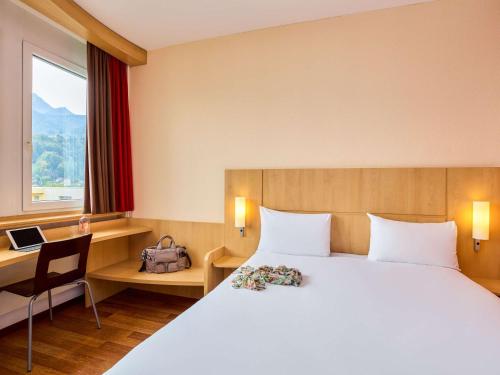 卢塞恩卢塞恩克林斯宜必思酒店的配有一张床、一张书桌和一扇窗户的酒店客房