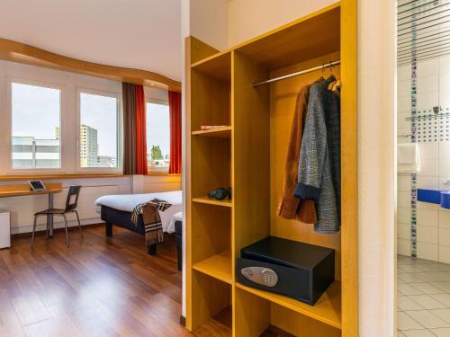 卢塞恩卢塞恩克林斯宜必思酒店的客房设有衣柜、床和书桌。