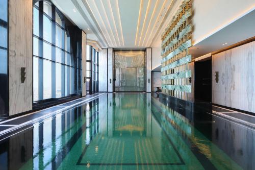 多哈Waldorf Astoria Doha West Bay的一座带窗户的建筑中的游泳池