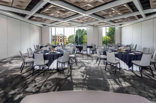 夏洛特Hyatt Centric Charlotte SouthPark的一间会议室,配有桌椅和大窗户
