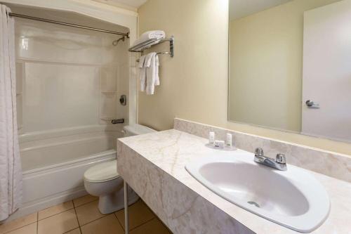 阿默斯特Travelodge by Wyndham Amherst的一间带水槽、浴缸和卫生间的浴室
