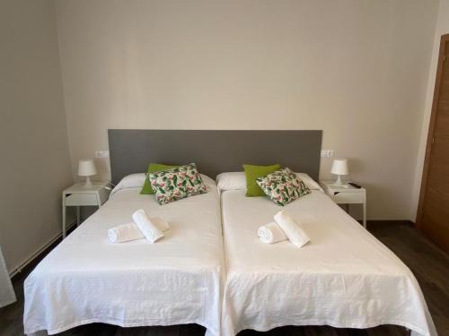 科鲁韦多HOSPEDAJE STOP的一间卧室配有两张床,提供白色的床单和绿色的枕头
