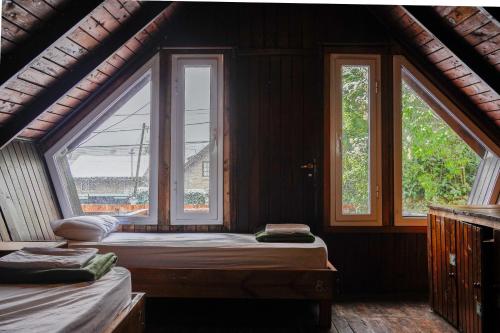 圣卡洛斯-德巴里洛切Alaska Patagonia Hostel的一间卧室设有两张床和两个窗户。