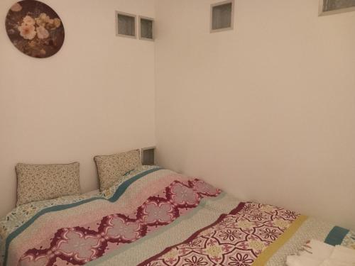 哈斯罗德Meerdaal Vakantie Studio的卧室配有一张床,墙上挂着一个钟