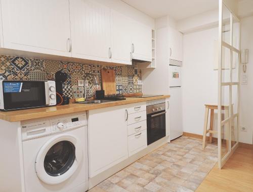拉科鲁尼亚Apartamento Bonhomía的厨房配有洗衣机和微波炉。