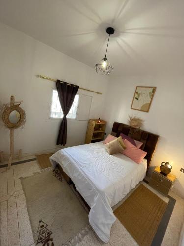 奥瑞尔K11SURF的一间卧室配有带白色床单和粉红色枕头的床。