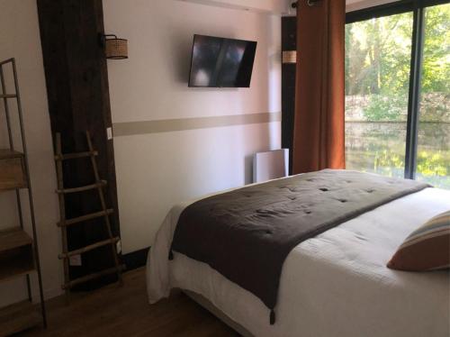 La cabane du pêcheur - Lodges de Bonfruit的一间卧室设有一张大床和一个窗户。