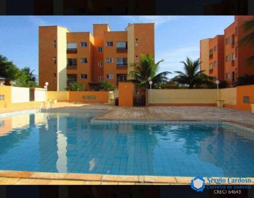 伊塔尼亚恩Apartamento em Itanhaém com 2 quartos, Piscina e Ampla Varanda Gourmet的一座大型游泳池,位于部分建筑前