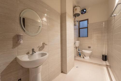 古瓦哈提Alhanney Housing的一间带水槽、镜子和卫生间的浴室