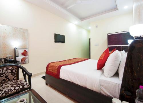 新德里Hotel Jiva Banquet的配有一张床和一把椅子的酒店客房