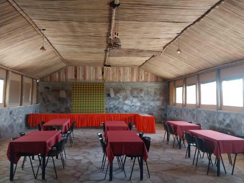 塔勒克Resian Mara Camp的一间大房间,里面设有红色的桌椅