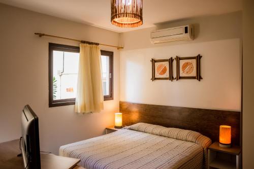 纳塔尔塞兰特斯公寓式酒店的一间卧室设有一张床和一个窗口