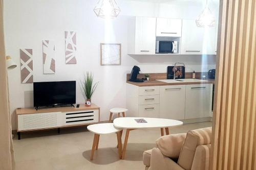 卢恰纳L'albizia Studio calme et tout confort的带沙发、电视和桌子的客厅