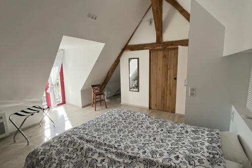 Nohant-VicMaison à proximité du village de George Sand的阁楼上的卧室配有一张大床
